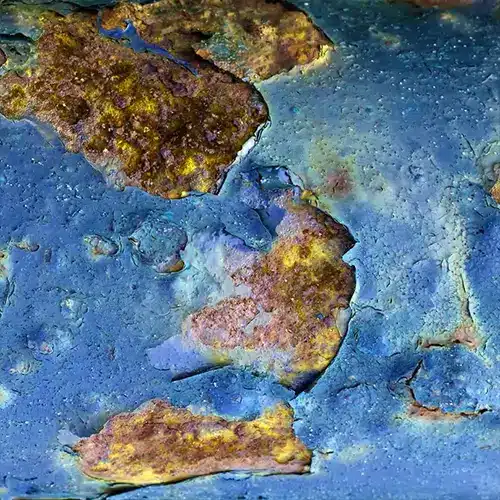 Ferrugem sob o revestimento industrial.